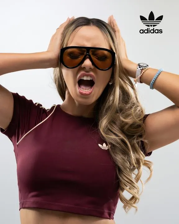 Modelo con gafas y camiseta adidas vino tinto gritando, fotografía de estudio