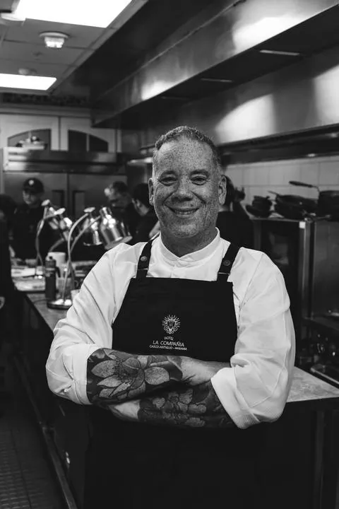 Chef del Hotel La Compañía con delantal, brazos cruzados en la cocina, en blanco y negro