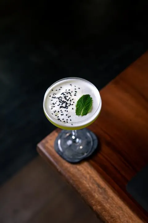 Cóctel blanco con semillas de sésamo y hoja de menta