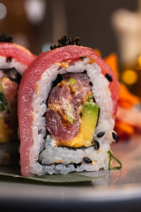 Primer plano de un roll de sushi de atún con aguacate