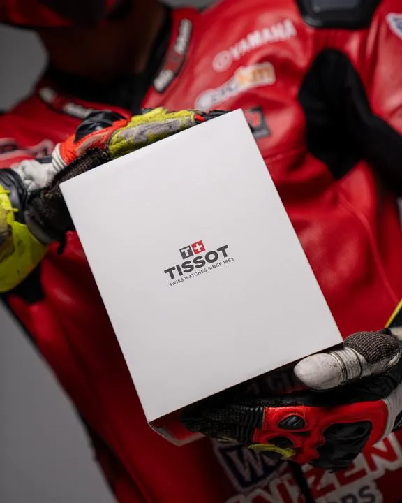 Piloto sosteniendo la caja de un reloj Tissot